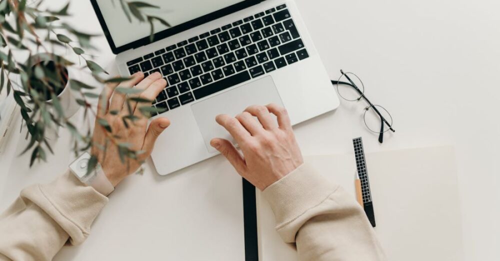 Productivity - Person in Beige Long Sleeve Shirt Using Macbook Pro