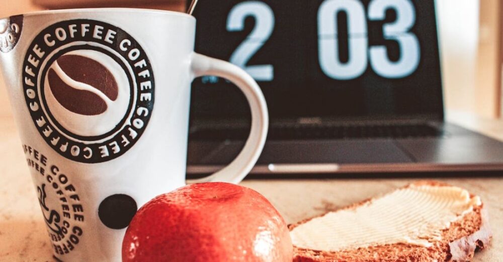 Productivity - Closeup Photo of White and Black Printed Ceramic Mug Beside Pastry