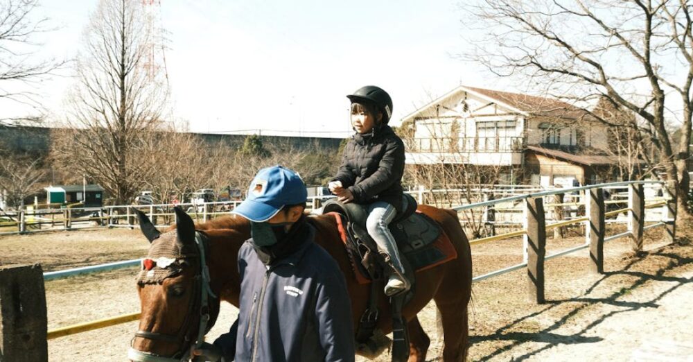 Learning Platforms - A man and a woman riding horses on a dirt path