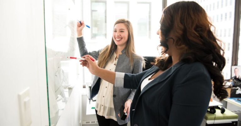 Employees - Two Women in Front of Dry-erase Board